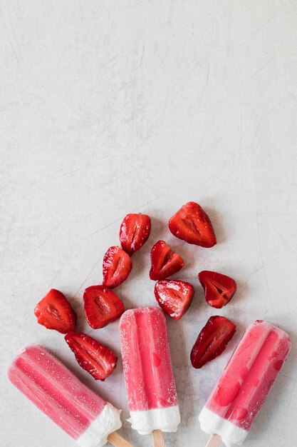 Top view of yummy popsicles with strawberry and copy space