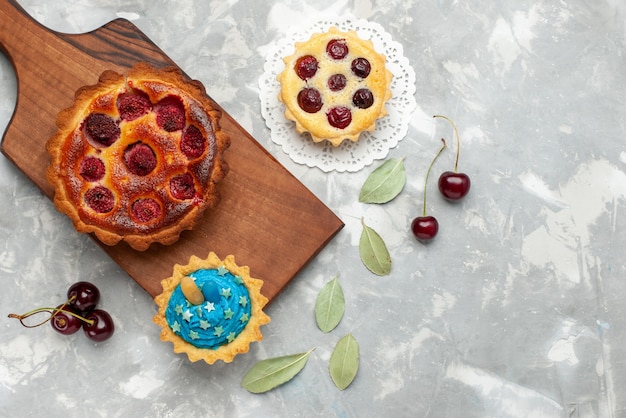 Top view yummy raspberry cake with cake and fresh sour cherries on the light background cake bake fruit pie