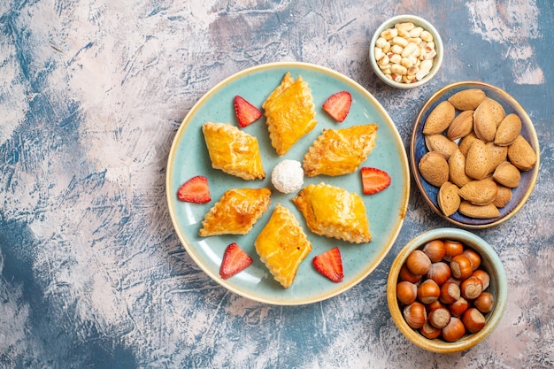 Top view yummy sweet cakes with nuts on a blue background