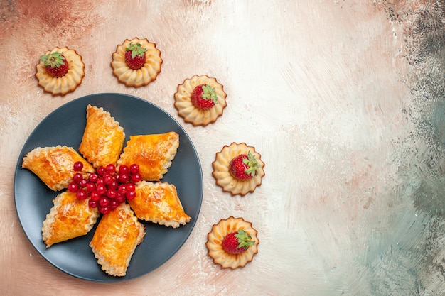 Top view yummy sweet pastries fruits and cookies on white pie cake pastry sweet