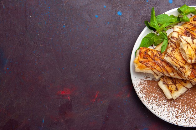 Top view yummy sweet pastries sliced inside plate on dark desk cookies biscuit sugar sweet cake tea