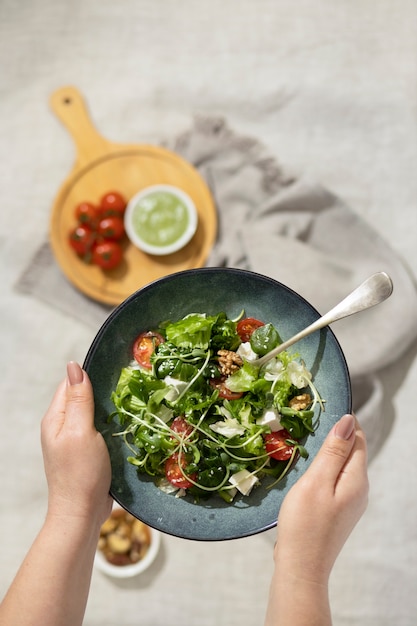 Top viewof person holding a plate of salad and a fork