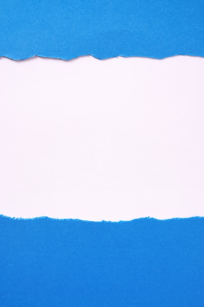 Free photo torn blue paper white background border frame vertical