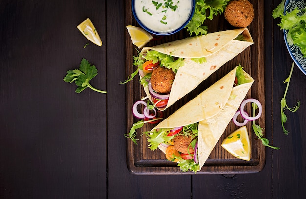 Free photo tortilla wrap with falafel and fresh salad. vegan tacos. vegetarian healthy food. top view