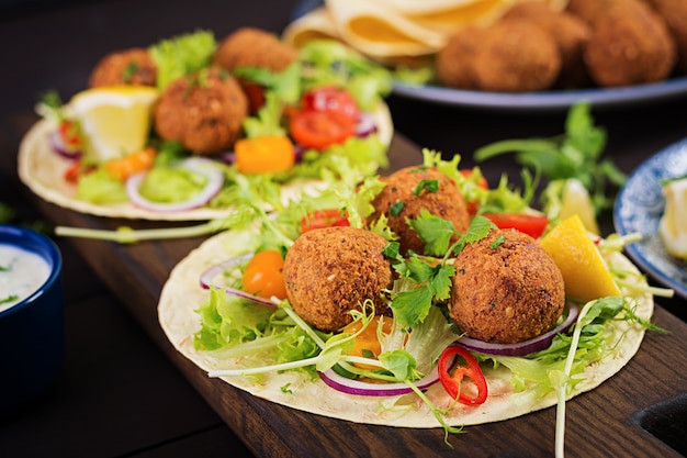 Tortilla wrap with falafel and fresh salad. Vegan tacos. Vegetarian healthy food.