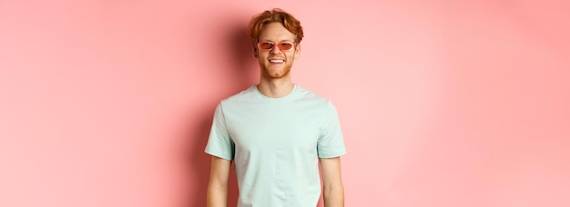 Free photo tourism and vacation concept cheerful redhead bearded man in sunglasses and tshirt smiling and looki