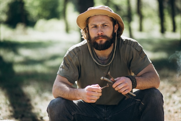 Tourist by bonfire in forest