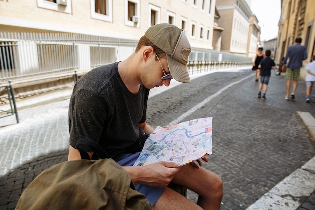 Free photo tourist considering map of city in rome