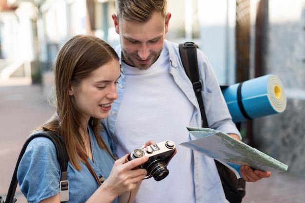 Tourist coupe outdoors with map and camera