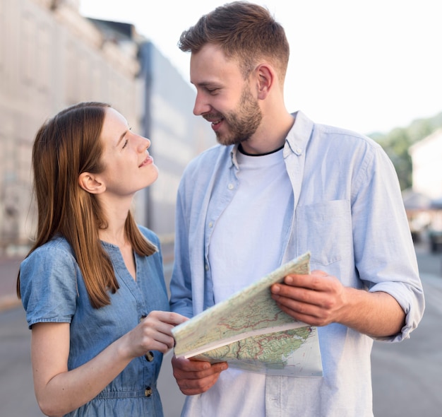 Free photo tourist couple holding map together