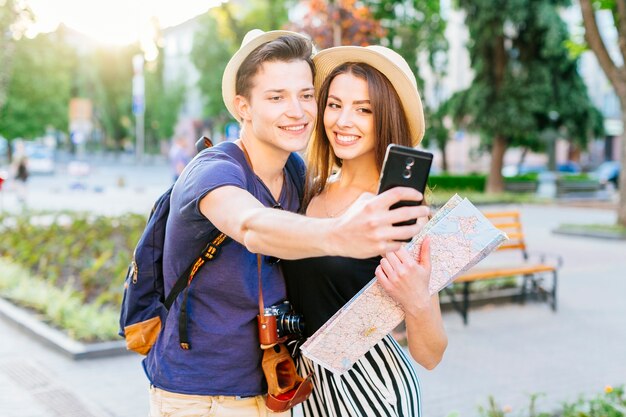 Tourist couple taking selfie in park