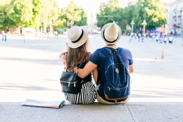 Tourist couple on vacations sitting in city