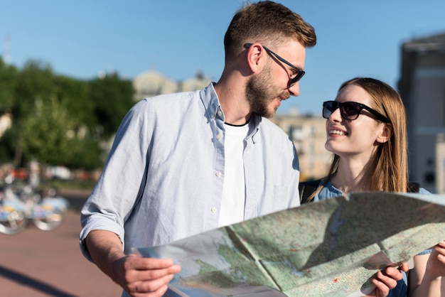 Tourist couple with sunglasses and map