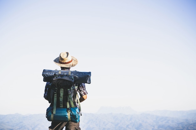 Free photo tourist  from mountain top. sun rays. man wear big backpack against sun light