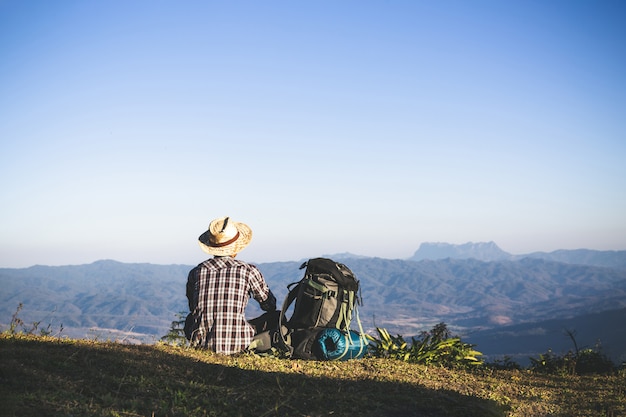 Free Photo tourist from mountain top. sun rays. man wear big backpack against sun light