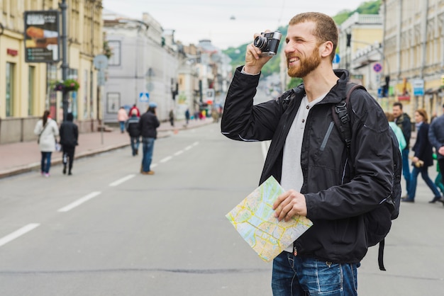 Free photo tourist man with map and camera