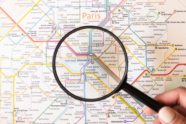 Free photo tourist showing a place in paris with magnifying glass