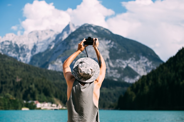 Free photo tourist taking photos of nature landscape using his smartphone