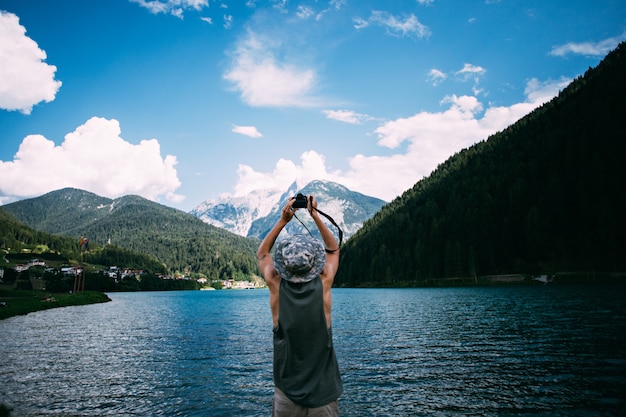 Free Photo tourist taking photos of nature landscape using his smartphone