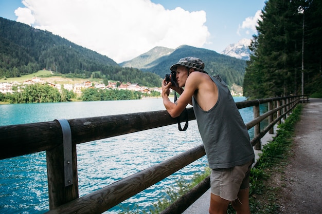 Free photo tourist taking photos of nature landscape using his smartphone