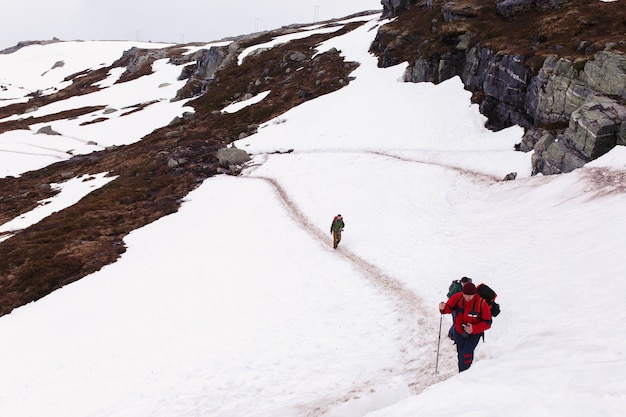 Tourist walk across the snow up in the mountains 