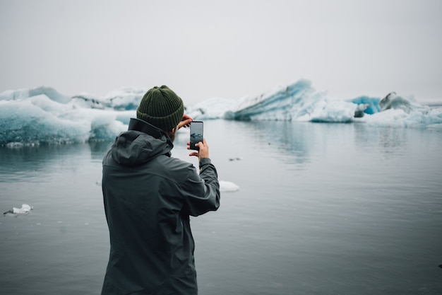 Free photo tourist watches glacier in water in iceland