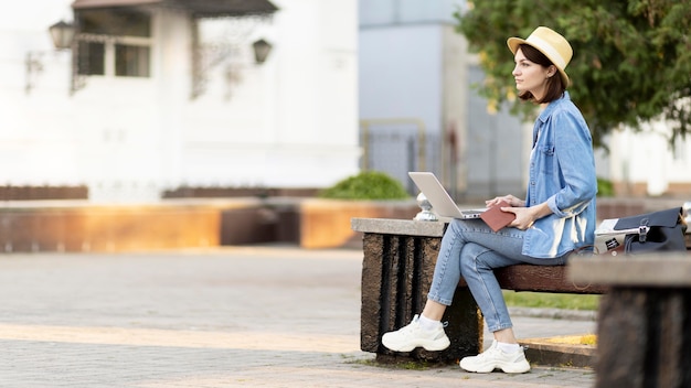 Tourist with hat sitting on a bench outdoors