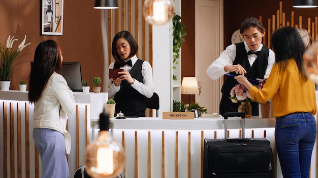 Free photo tourists going through check in process at hotel reception desk