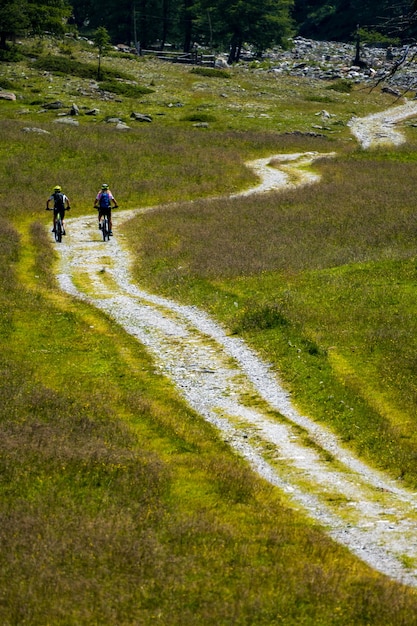 Tourists riding a bicycle in a meadow with a beautiful landscape