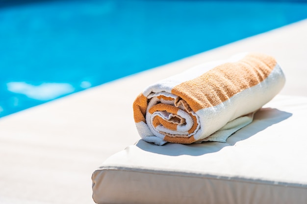 Towel on bed around swimming pool in hotel resort