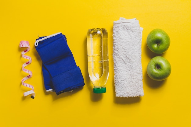 Free photo towel with other sports accessories on yellow surface