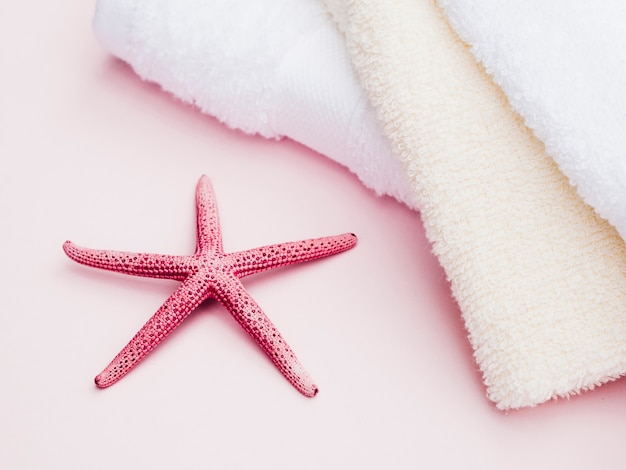 Towels and starfish on pink background