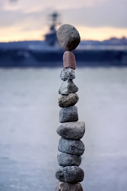 Tower of stones with a ship as background