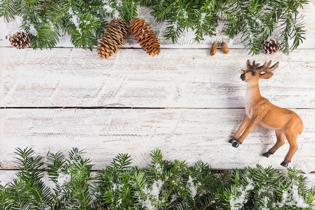 Free Photo toy deer and fir twigs on wood board 