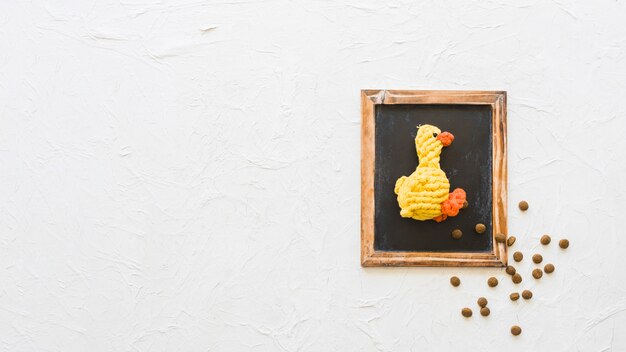 Toy duck and pet food on chalkboard