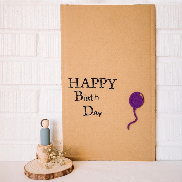 Free photo toy figure near cardboard with birthday greeting