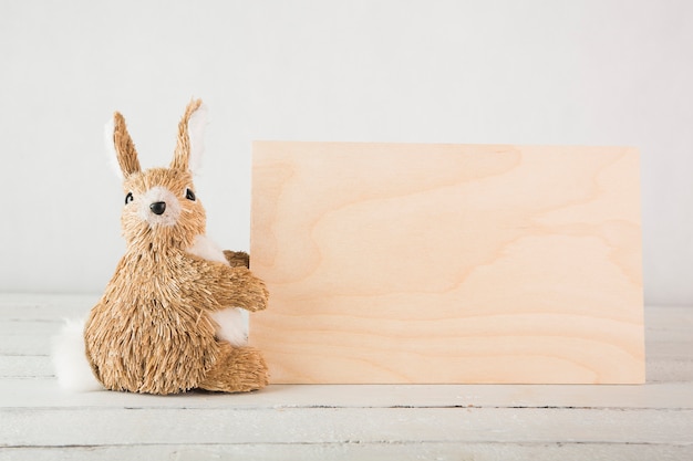 Free photo toy rabbit near wooden board