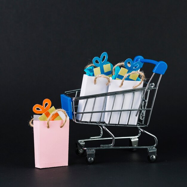 Toy supermarket cart with gifts in packets 