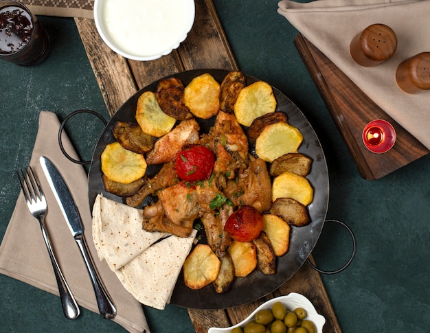 Traditional azerbaijan dish served with yogurt on a wooden board with cutlery