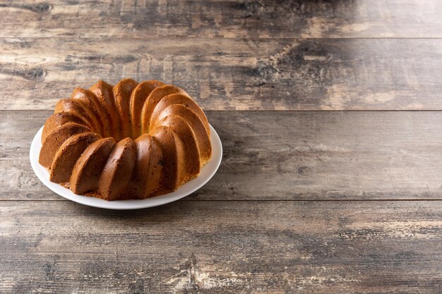 Traditional bundt cake piece with raisins on wooden table