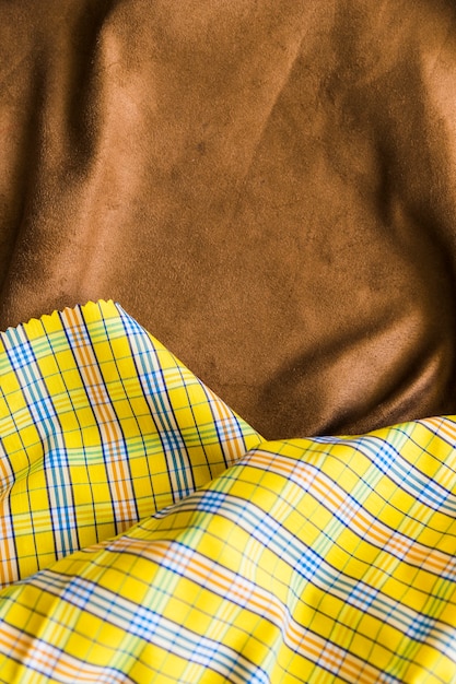 Free photo traditional checkered fabric texture on brown drape textile