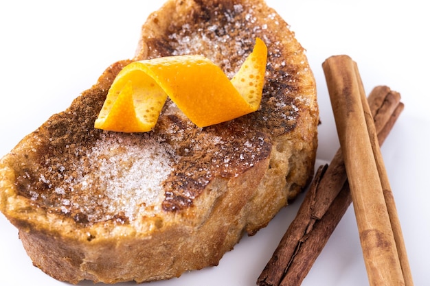 Traditional homemade Spanish torrijas decorated with cinnamon and Orange peel isolated on white background