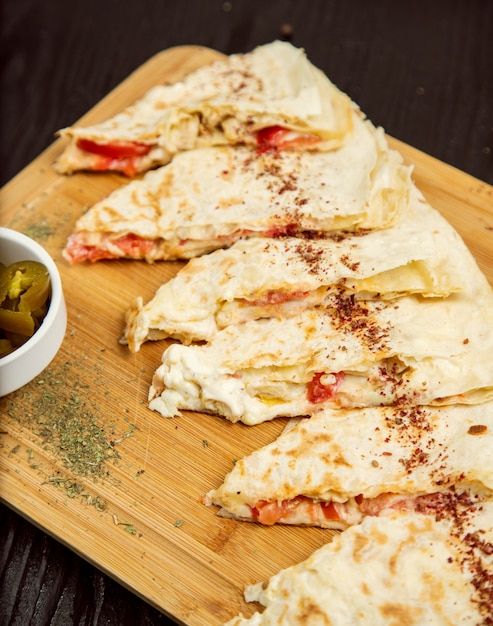 Traditional meat vegetable gutab, qutab, gozleme on wooden board with sumakh, turshu . 