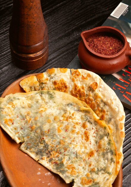 Traditional meat vegetable gutab, qutab, gozleme on wooden board with sumakh 