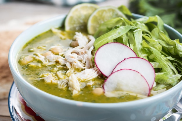 Free photo traditional mexican green pozole soup on wooden table