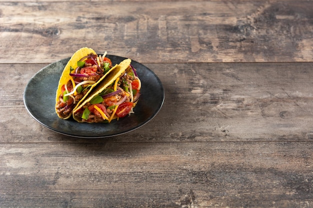 Free photo traditional mexican tacos with meat and vegetables on wooden table