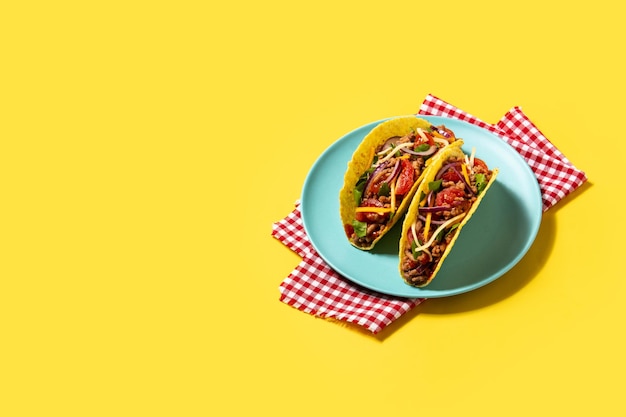 Free photo traditional mexican tacos with meat and vegetables on yellow background