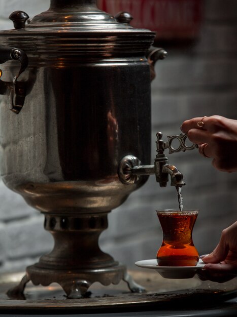 Traditional samovar tea putting into glass