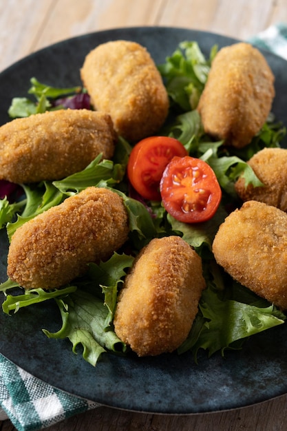 Traditional spanish fried croquettes on wooden table