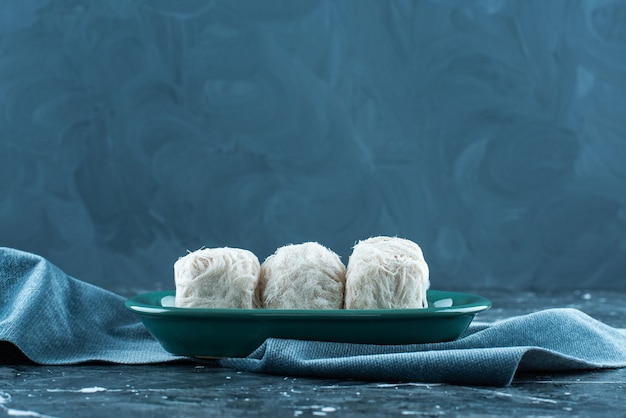 Traditional Turkish cotton candy on a plate on a towel , on the blue table. 